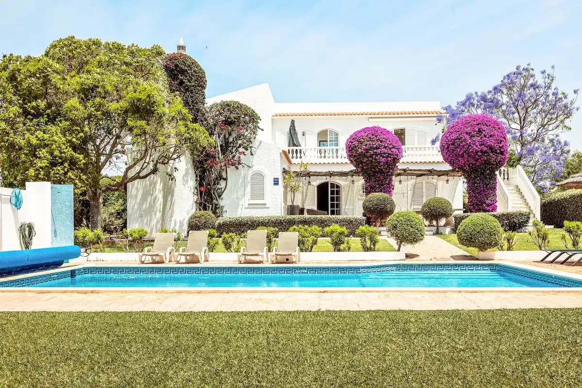Pool terrace with sun loungers and bougainvillea at Casa da Parra
